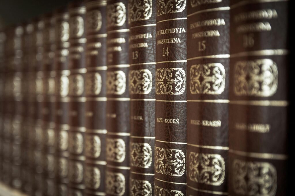 A close-up view of vintage encyclopedias on a library bookshelf, highlighting the ornate leather bindings.